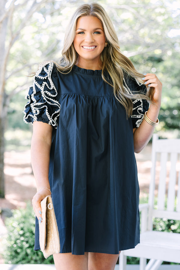 Navy cotton mini dress featuring a high neckline and tiered ruffle sleeves with white trim.