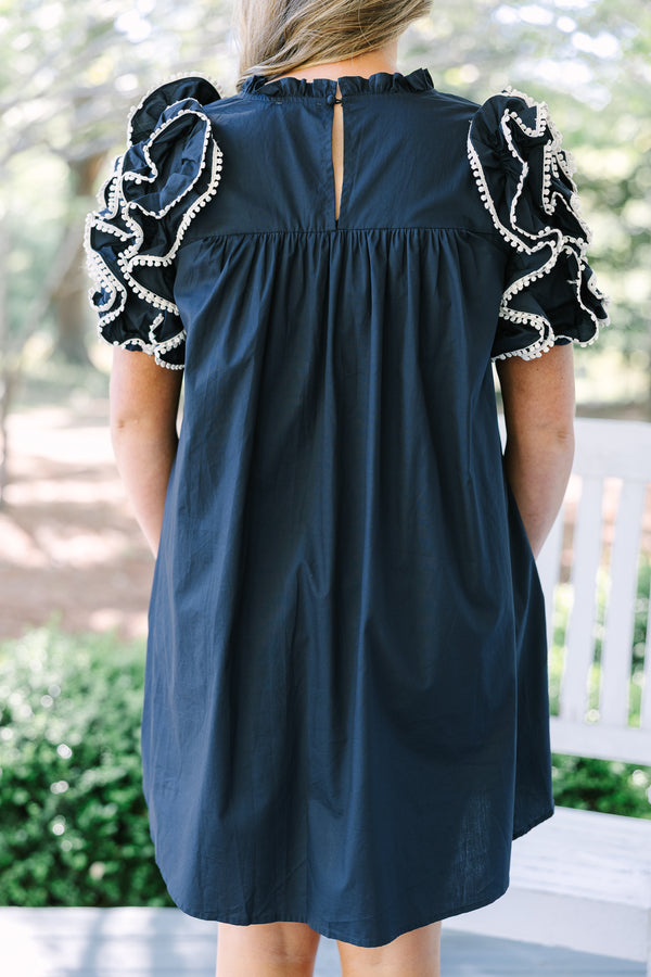 Navy cotton dress with ruffled pom-pom sleeves and a back keyhole closure.