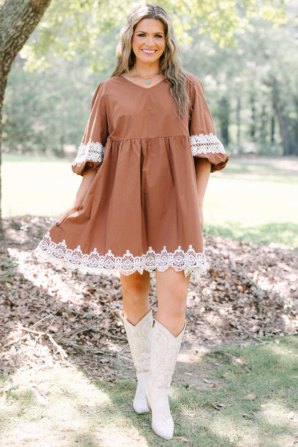Plus size brown babydoll mini dress with puff sleeves and white crochet lace trim on hem and cuffs.