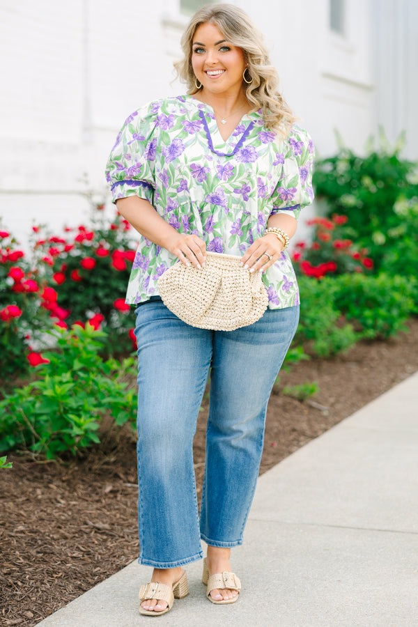Chic Soul plus size clothing, a purple, green, and white floral peplum style top feature a puff sleeve and a notch style V-neck collar. There is contrasting purple scallop trim on the sleeves and collar