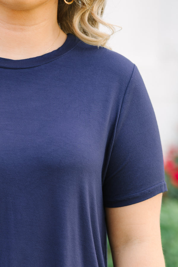Close-up of a navy blue short-sleeve tunic top with a round neckline and soft, jersey fabric.