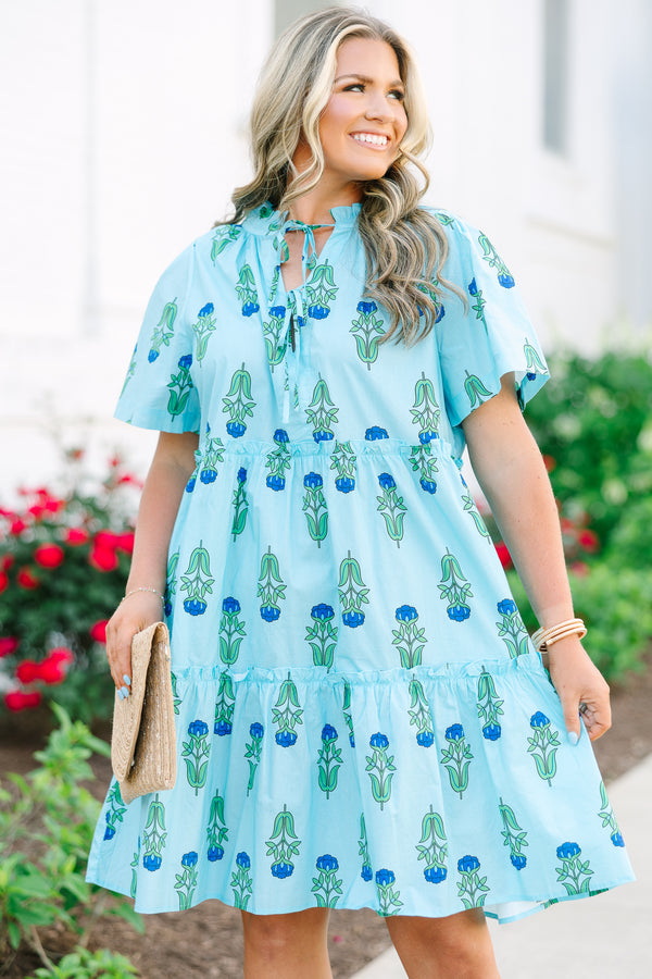 Chic Soul plus size clothing, light blue tiered knee length dress with a dark blue and green floral pattern as well as two bows that tie  on the across the v-neckline 