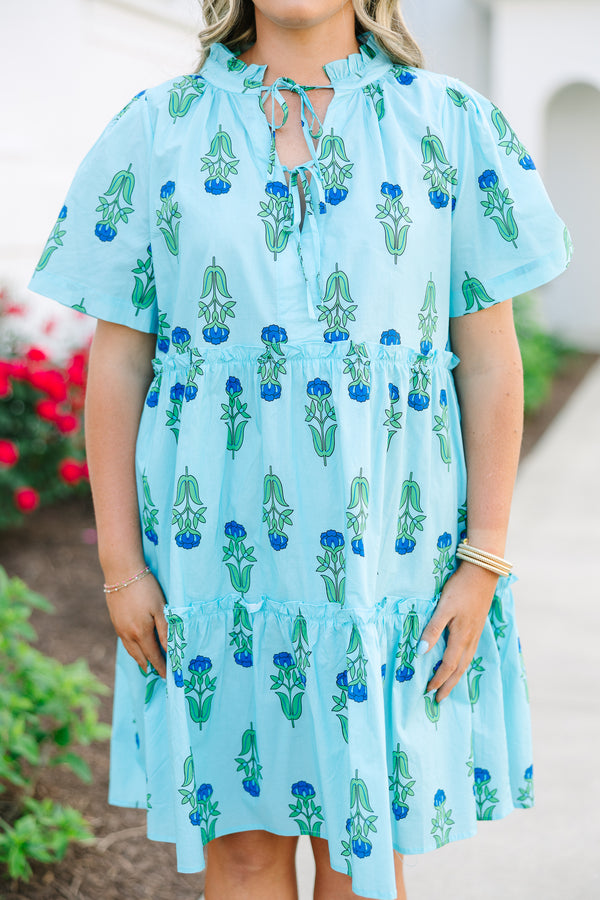 Chic Soul plus size clothing, light blue tiered knee length dress with a dark blue and green floral pattern as well as two bows that tie  on the across the v-neckline 