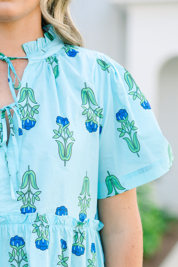 Chic Soul plus size clothing, light blue tiered knee length dress with a dark blue and green floral pattern as well as two bows that tie  on the across the v-neckline 