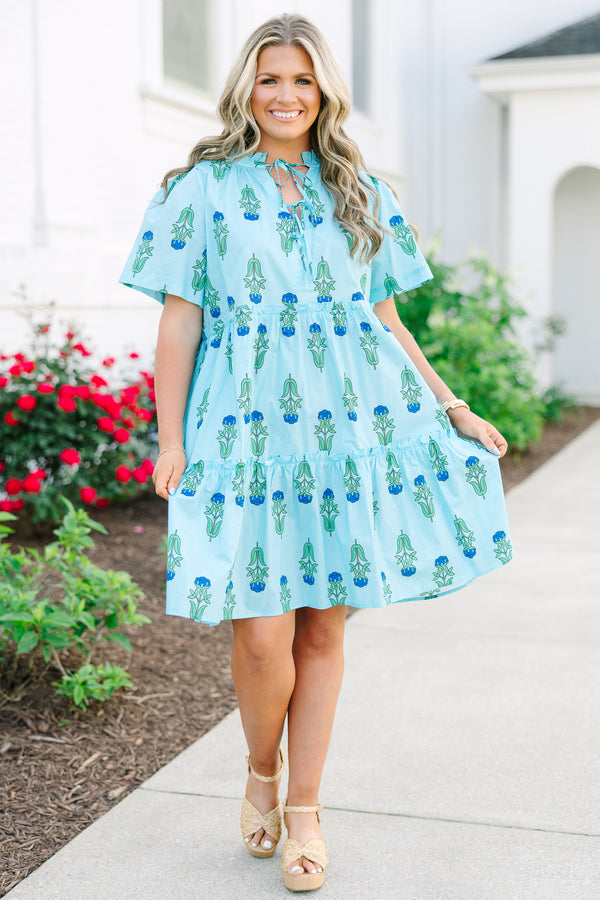 Chic Soul plus size clothing, light blue tiered knee length dress with a dark blue and green floral pattern as well as two bows that tie  on the across the v-neckline 
