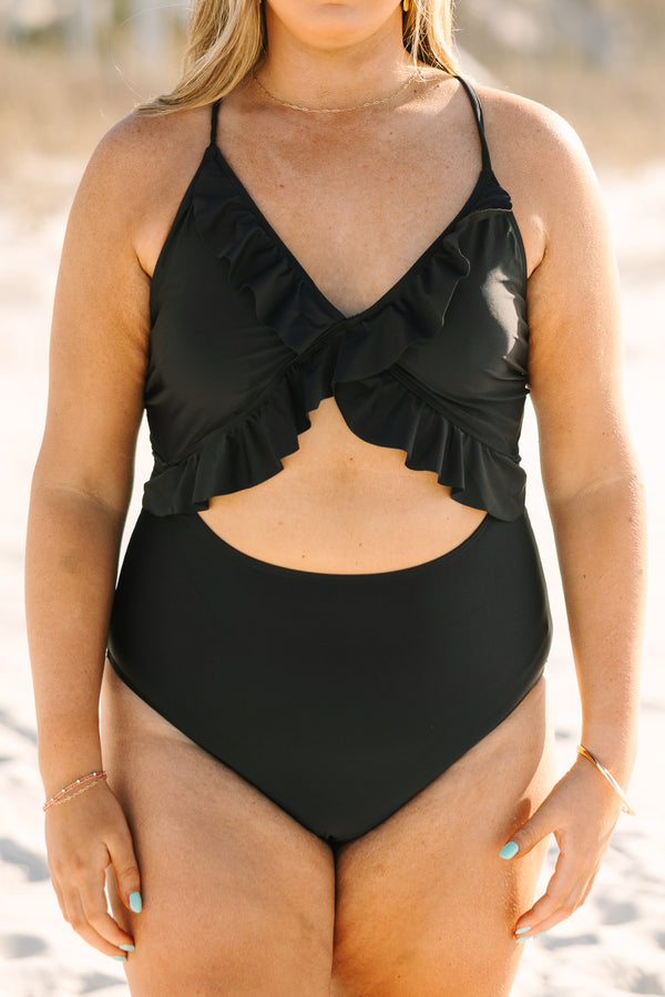 Plus Size black one-piece swimsuit with a front cutout, ruffle trim, and adjustable corset back.