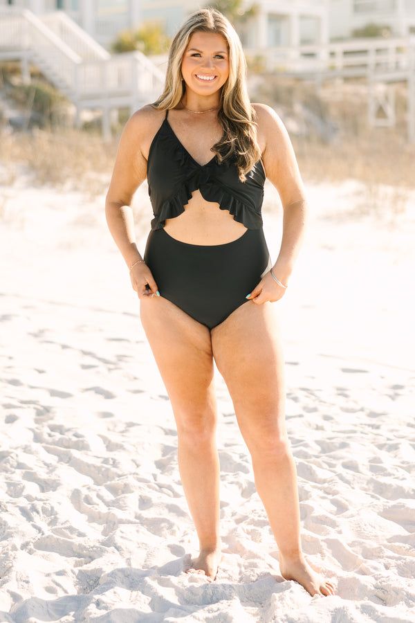 Plus Size black one-piece swimsuit with a front cutout, ruffle trim, and adjustable corset back.