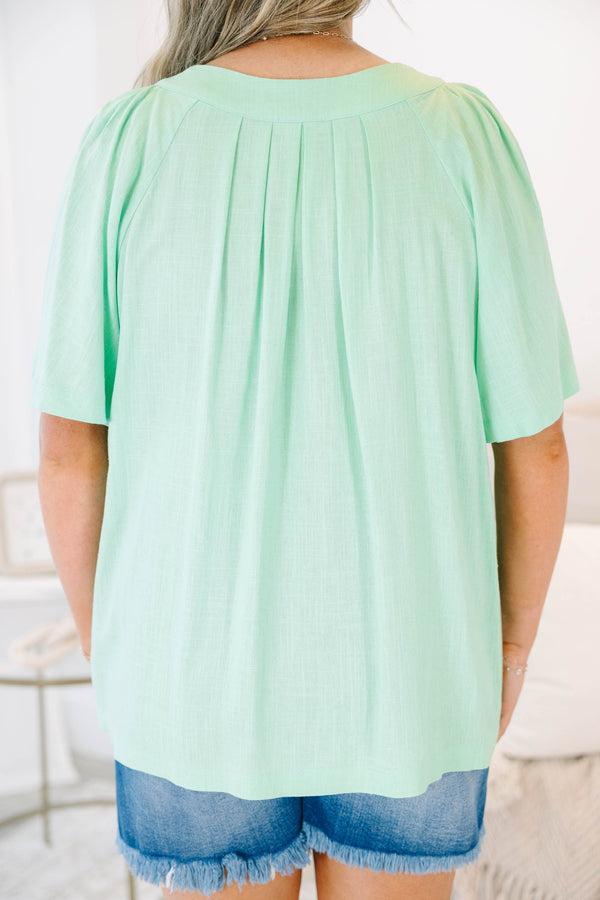 Plus size mint green flowy top with a split neckline and short flutter sleeves.