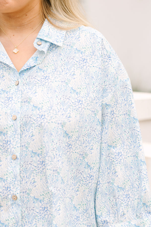 Chic Soul plus size clothing, cerulean top with long sleeves and buttons going down the center of the top as well as a ruffle detail at the bottom of the top and a thin floral pattern throughout 