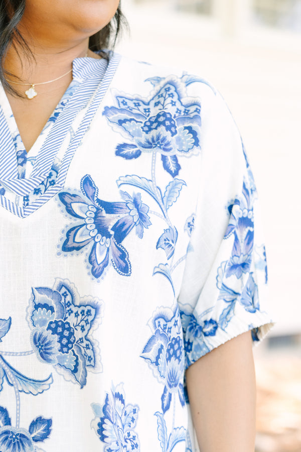 Plus Size white and blue floral print top with a striped V-neckline and short puff sleeves.