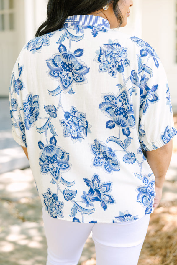Plus Size white and blue floral print top with a striped V-neckline and short puff sleeves.