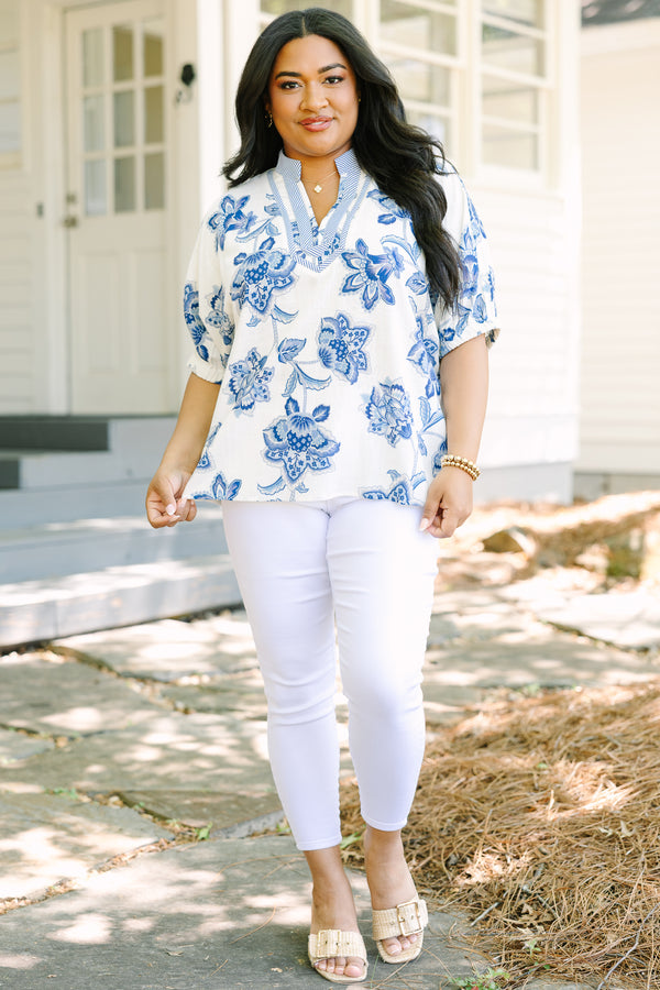 Plus Size white and blue floral print top with a striped V-neckline and short puff sleeves.