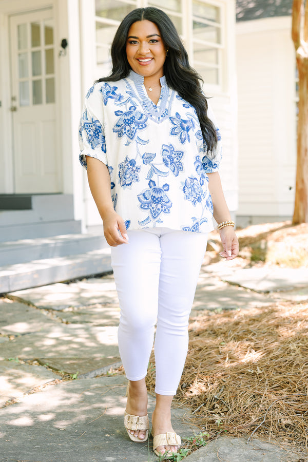 Plus Size white and blue floral print top with a striped V-neckline and short puff sleeves.