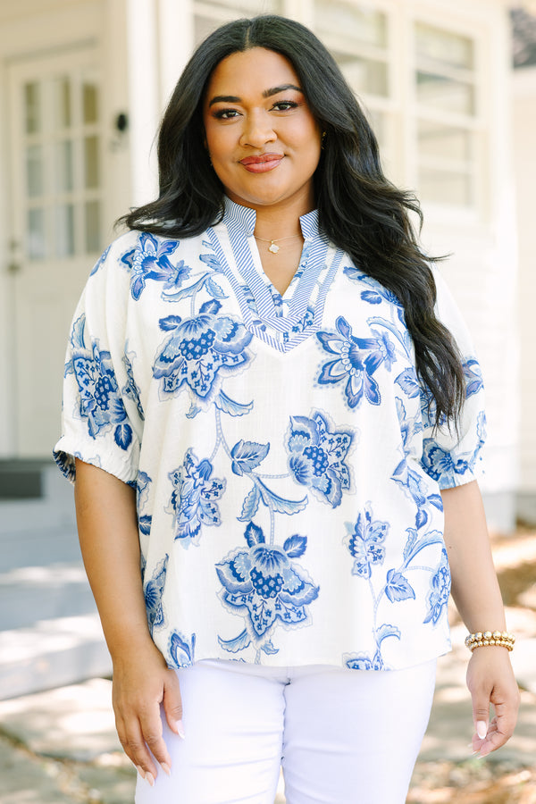 Plus Size white and blue floral print top with a striped V-neckline and short puff sleeves.