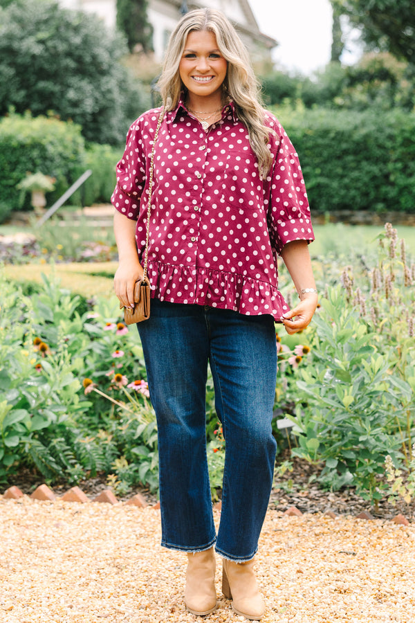 Plus Size wine-colored button-down cotton top with white polka dots, short sleeves, and ruffle hem.