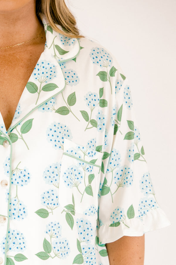 Plus Size short-sleeve pajama set with blue hydrangea print, ruffle trim, and button-down front.