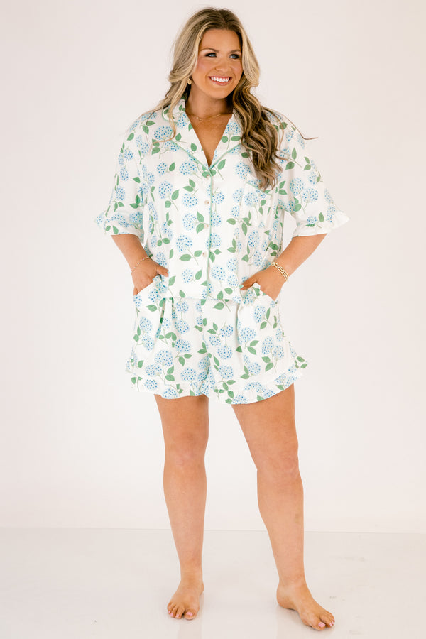 Plus Size short-sleeve pajama set with blue hydrangea print, ruffle trim, and button-down front.