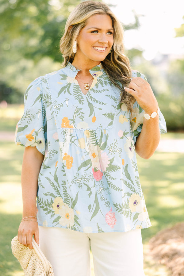 Plus Size light blue floral babydoll top with puff sleeves, a ruffled neckline, and a v-cutout.