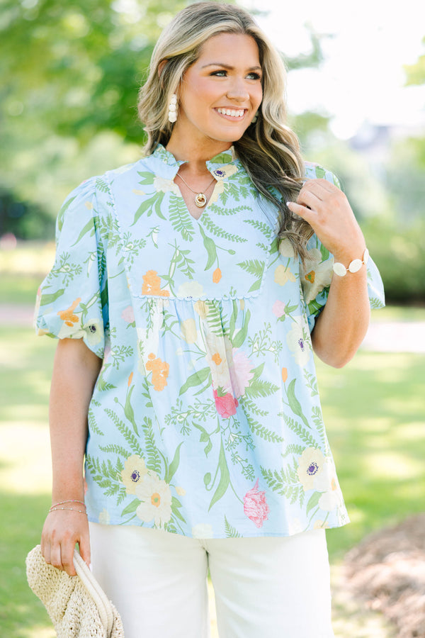 Plus Size light blue floral babydoll top with puff sleeves, a ruffled neckline, and a v-cutout.