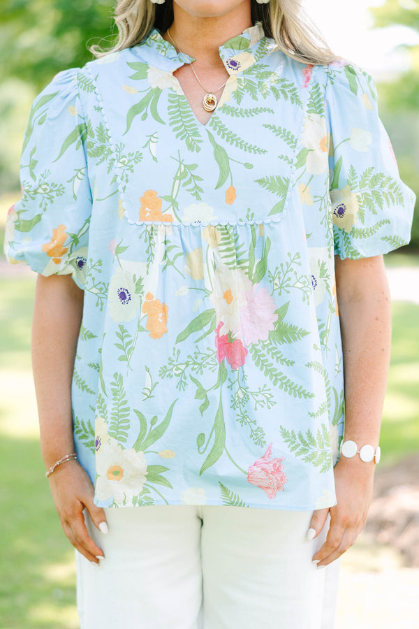 Plus Size light blue floral babydoll top with puff sleeves, a ruffled neckline, and a v-cutout.