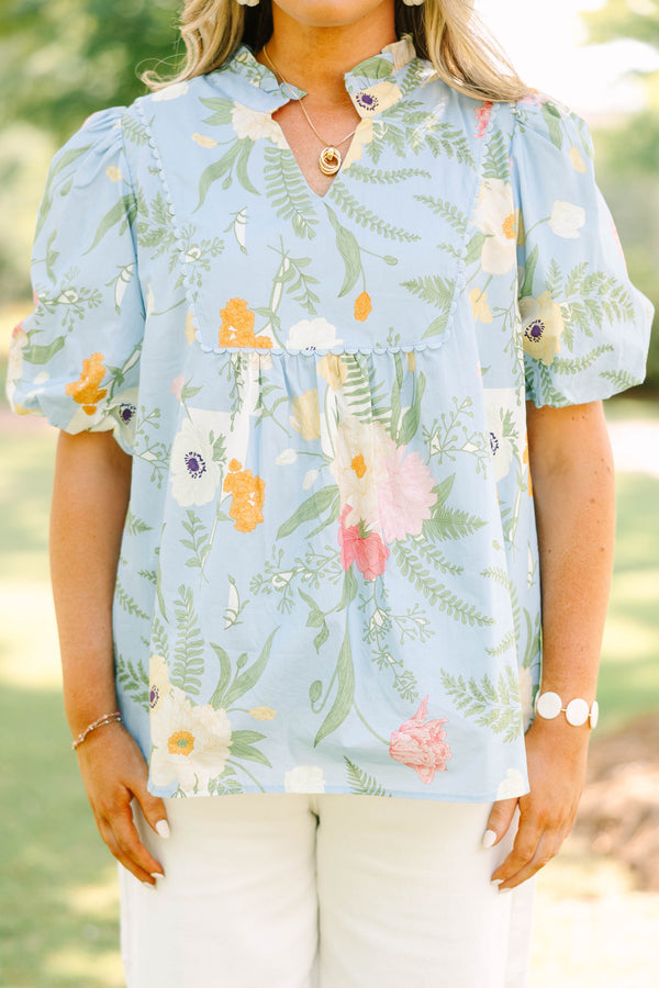 Plus Size light blue floral babydoll top with puff sleeves, a ruffled neckline, and a v-cutout.