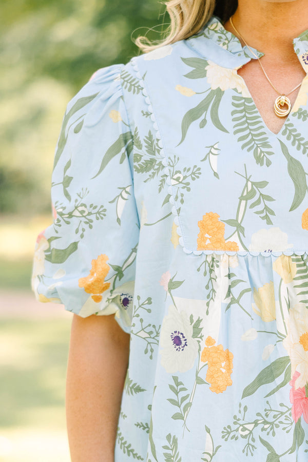 Plus Size light blue floral babydoll top with puff sleeves, a ruffled neckline, and a v-cutout.