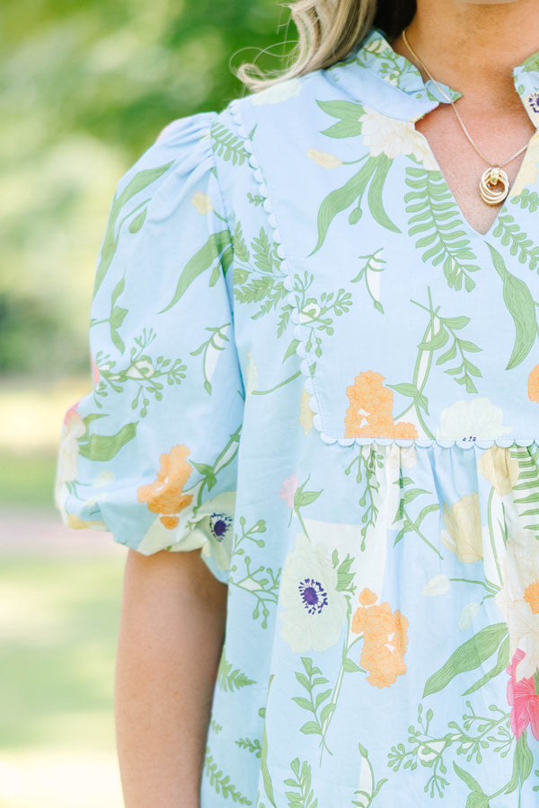 Plus Size light blue floral babydoll top with puff sleeves, a ruffled neckline, and a v-cutout.