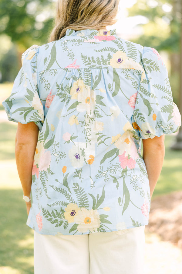 Plus Size light blue floral babydoll top with puff sleeves, a ruffled neckline, and a v-cutout.