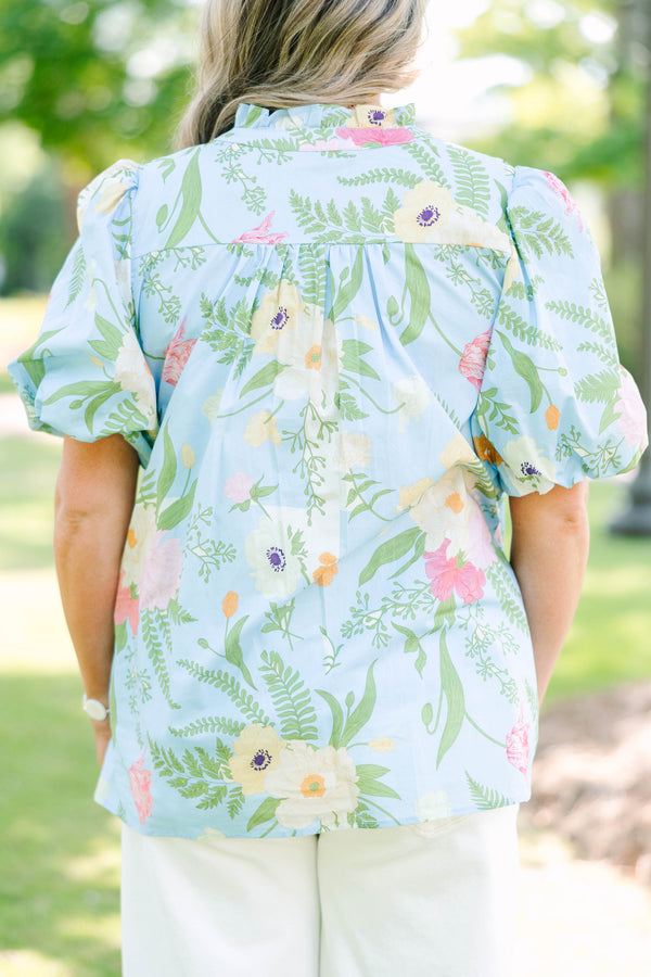 Plus Size light blue floral babydoll top with puff sleeves, a ruffled neckline, and a v-cutout.