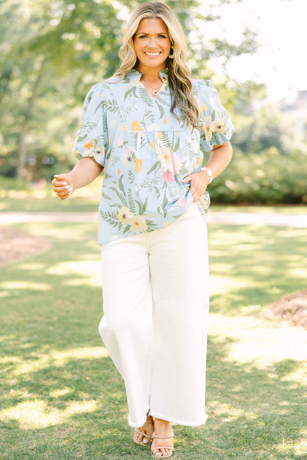 Plus Size light blue floral babydoll top with puff sleeves, a ruffled neckline, and a v-cutout.
