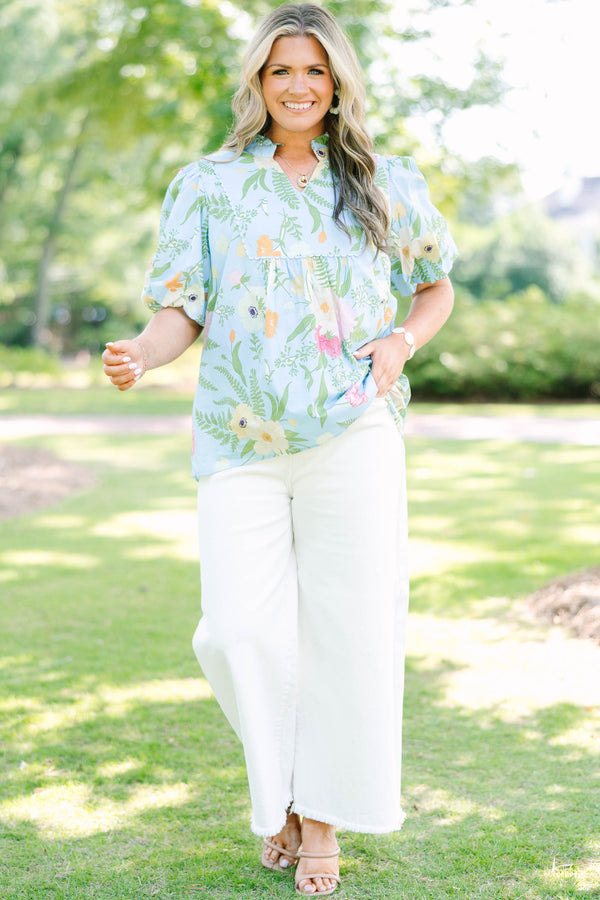 Plus Size light blue floral babydoll top with puff sleeves, a ruffled neckline, and a v-cutout.