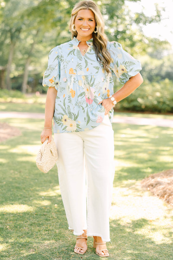 Plus Size light blue floral babydoll top with puff sleeves, a ruffled neckline, and a v-cutout.