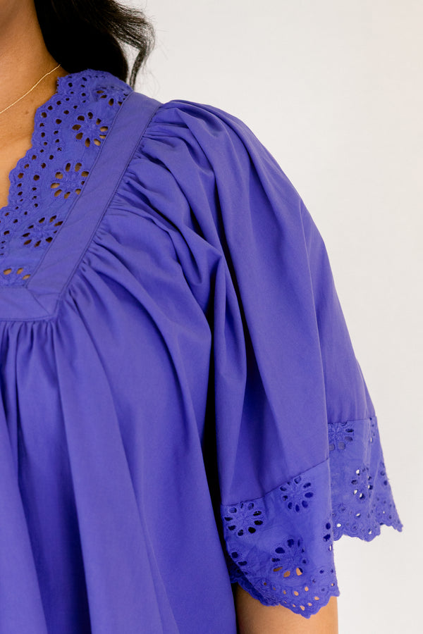 Chic Soul plus size clothing, blue flowy short sleeve top with eyelet detailing on the edges of the sleeves, bottom of top, and bordering v-neckline