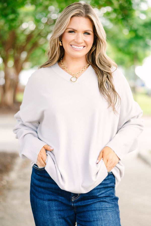 Plus size taupe-gray V-neck sweater with a relaxed, flowy fit and soft, stretchy fabric.