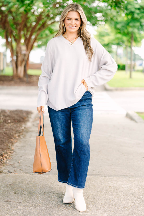 Plus size taupe-gray V-neck sweater with a relaxed, flowy fit and soft, stretchy fabric.