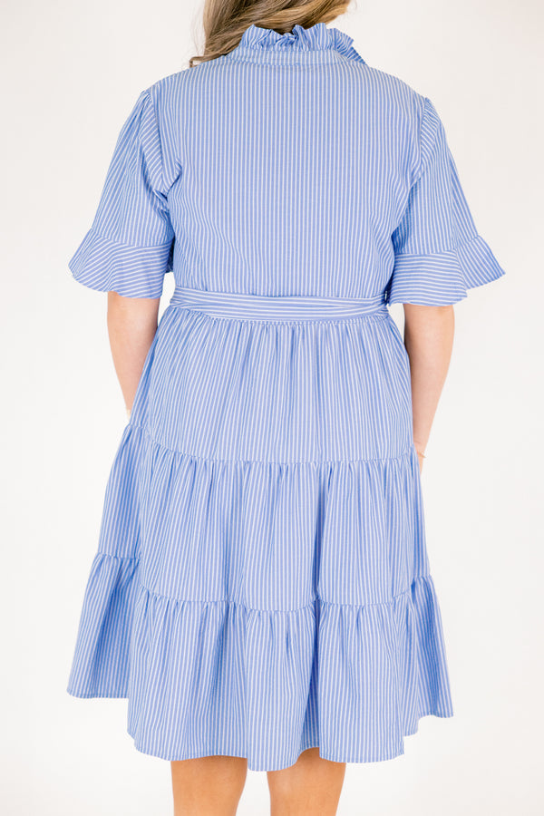Chic Soul plus size clothing, blue striped tiered midi dress with short sleeves that have a ruffle at the end of them as well as a ruffle detail going around the collar and down the buttons on the chest and a belt that ties into a bow that goes around the waist