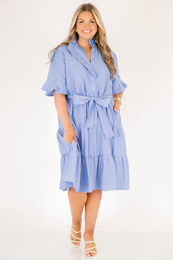 Chic Soul plus size clothing, blue striped tiered midi dress with short sleeves that have a ruffle at the end of them as well as a ruffle detail going around the collar and down the buttons on the chest and a belt that ties into a bow that goes around the waist