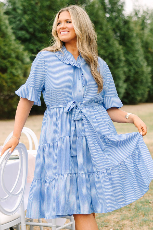Chic Soul plus size clothing, blue striped tiered midi dress with short sleeves that have a ruffle at the end of them as well as a ruffle detail going around the collar and down the buttons on the chest and a belt that ties into a bow that goes around the waist
