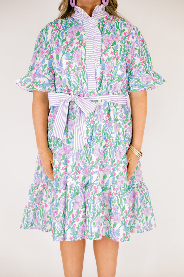 Chic Soul plus size clothing, purple floral midi dress with short sleeves that have a ruffle detail at the bottom of each sleeves as well as a striped purple pattern going down the chest and along the neckline as well as a striped belt that ties around the waist 