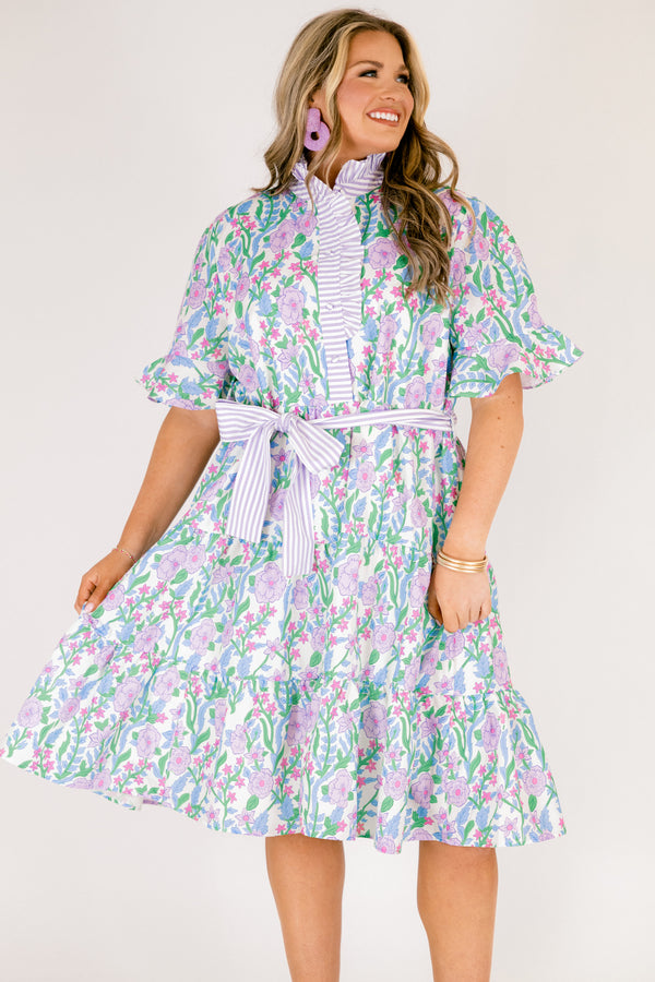 Chic Soul plus size clothing, purple floral midi dress with short sleeves that have a ruffle detail at the bottom of each sleeves as well as a striped purple pattern going down the chest and along the neckline as well as a striped belt that ties around the waist 