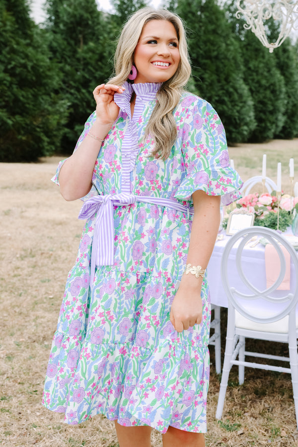 Chic Soul plus size clothing, purple floral midi dress with short sleeves that have a ruffle detail at the bottom of each sleeves as well as a striped purple pattern going down the chest and along the neckline as well as a striped belt that ties around the waist 