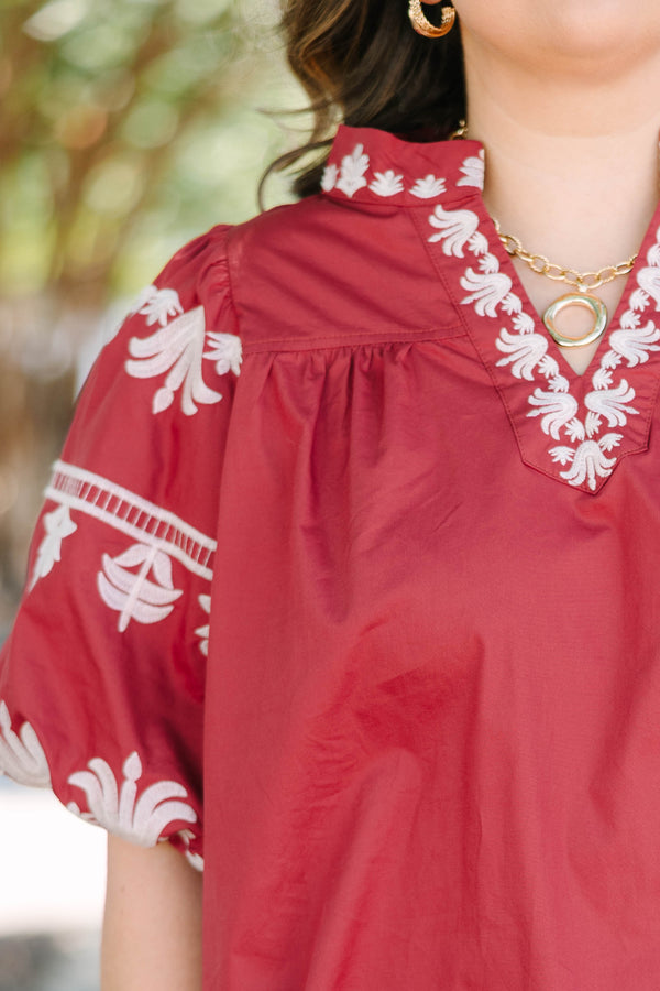 Plus size crimson cotton top with white embroidery, V-neckline, and flowy puff sleeves.