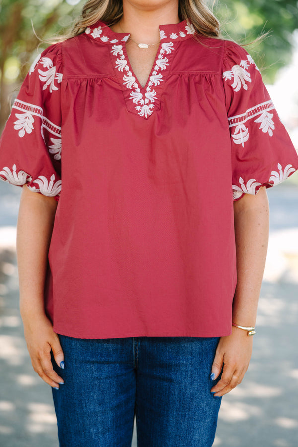 Plus size crimson cotton top with white embroidery, V-neckline, and flowy puff sleeves.