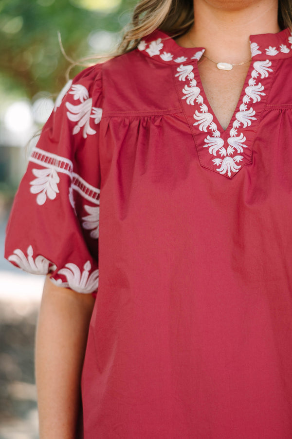 Plus size crimson cotton top with white embroidery, V-neckline, and flowy puff sleeves.