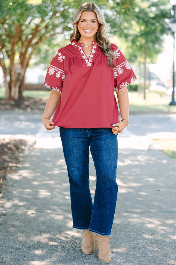 Plus size crimson cotton top with white embroidery, V-neckline, and flowy puff sleeves.