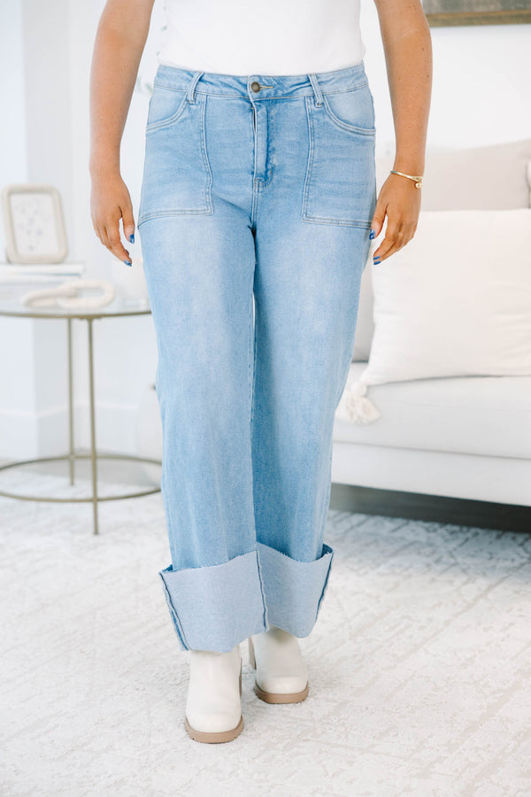 Plus size light wash high-rise wide-leg jeans featuring oversized cuffed hems and patch pockets.