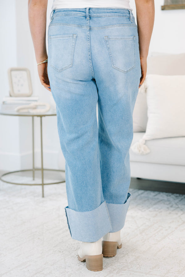 Plus size light wash high-rise wide-leg jeans featuring oversized cuffed hems and patch pockets.