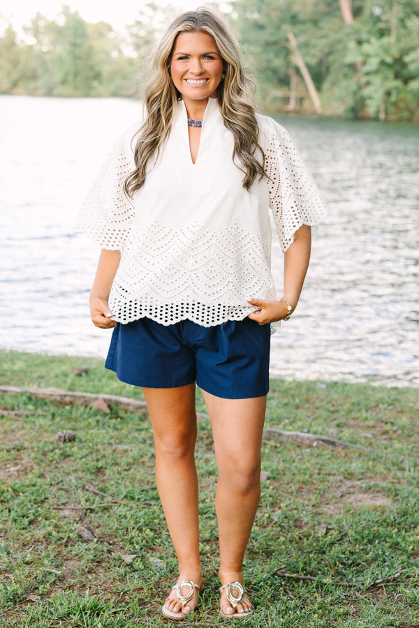 Plus Size white eyelet top with a split neckline, flutter sleeves, and a scalloped hemline.
