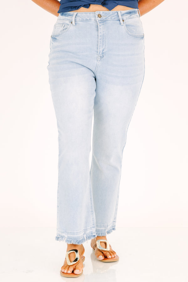 Plus Size light wash flare jeans with a high-rise fit and frayed raw hems.