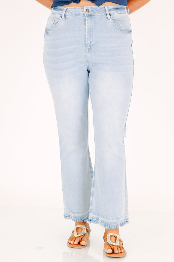 Plus Size light wash flare jeans with a high-rise fit and frayed raw hems.